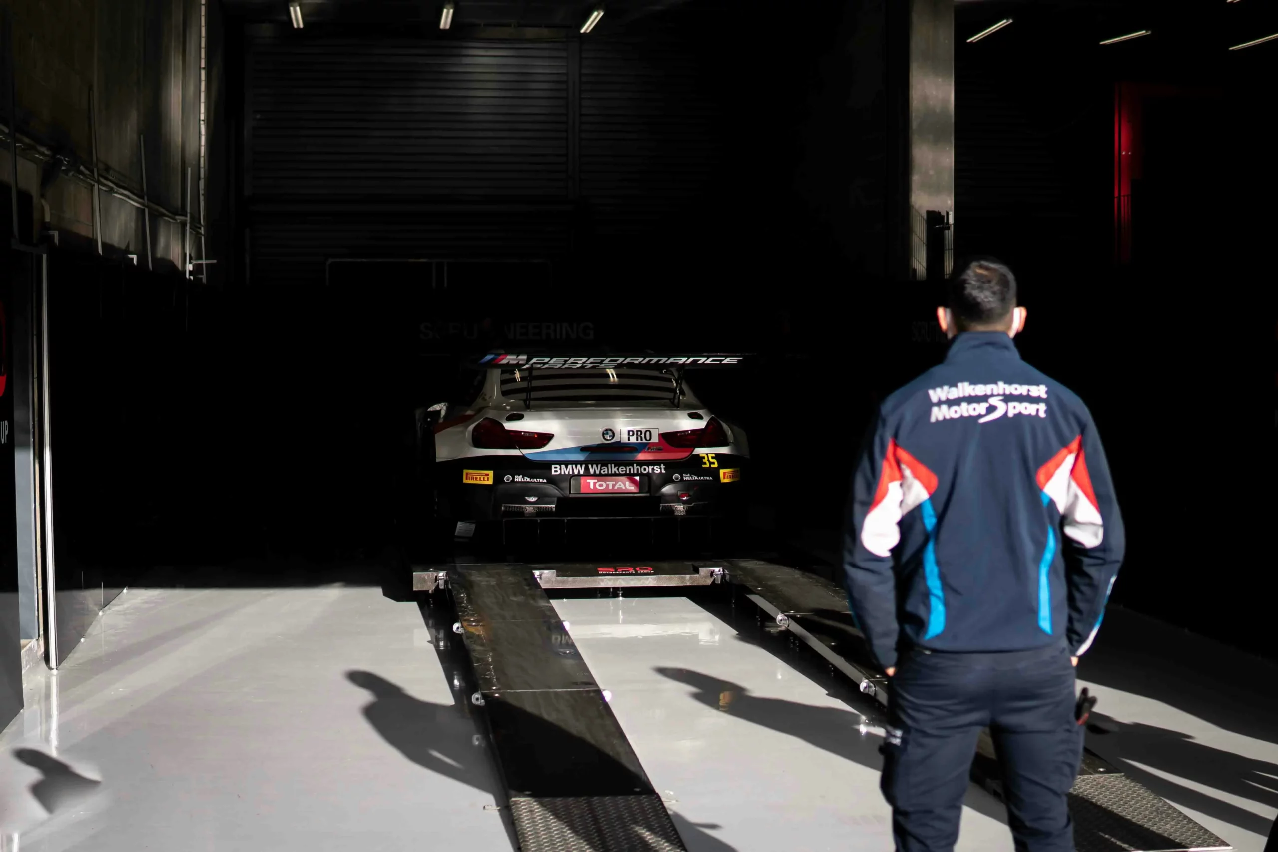 Man watching a BMW sports-car be removed from storage