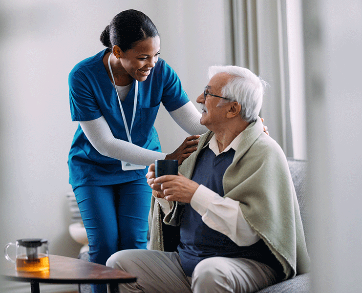 caregiver covering a senior's shoulders with a blanket